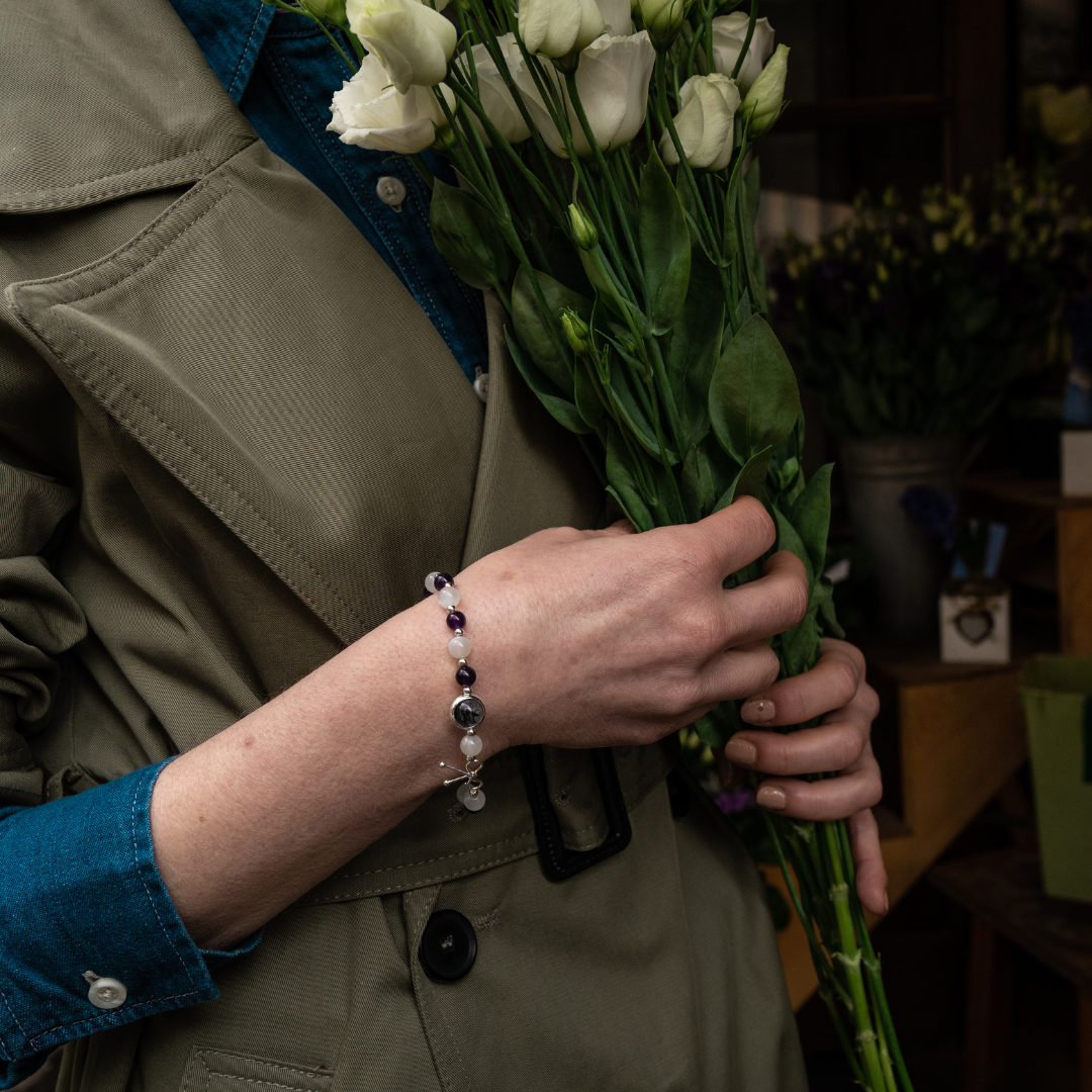Bracelet amincissant composé d'améthyste et de pierre de lune qui alternent avec de petites billes en argent 925 entre elles, avec une seule pierre de quartz rutile en son centre, entourée d'un anneau en argent 925