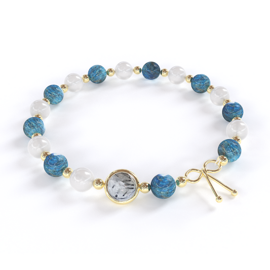 Bracelet  Détoxifiant  composé de pierre naturelle d'Apatite bleue et Pierre de Lune , alternant avec de petites billes en or , avec une seule pierre de quartz rutile en son centre, ainsi qu'un noeud en or